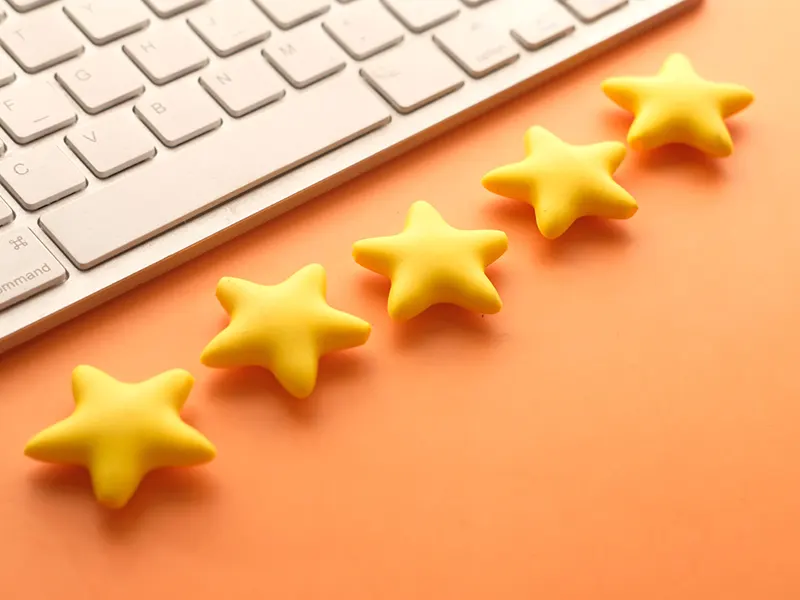 Underpinning Contractors in New York - Five Yellow Stars in Front of a Keyboard on a Peach Colored Desk